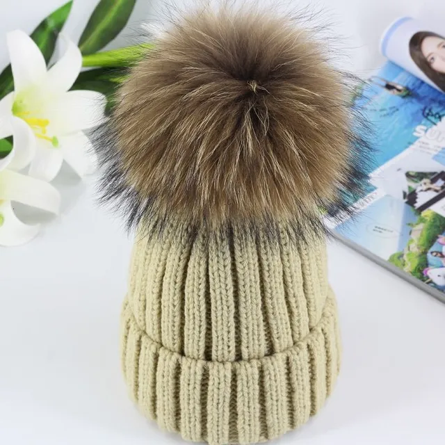 Women's winter knitted hat with pompom made of faux fur