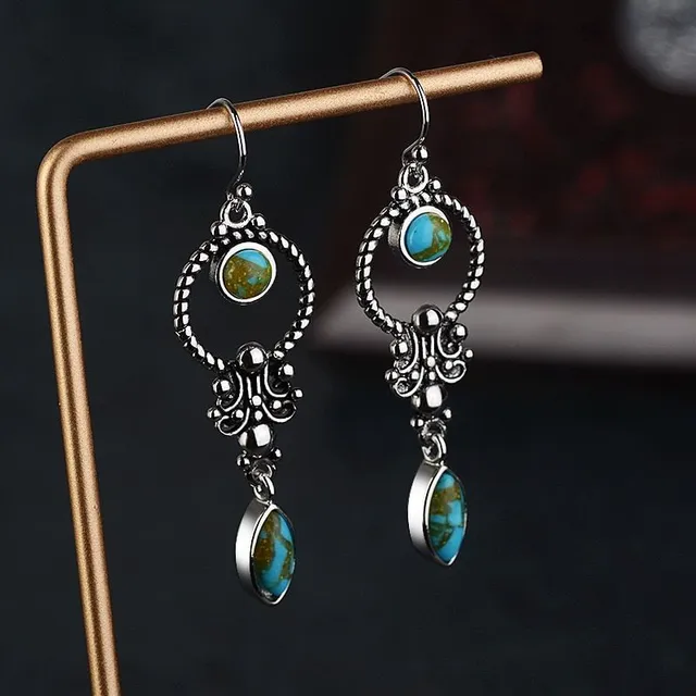 Luxurious ladies hanging earrings in Gothic style with detail of green stones