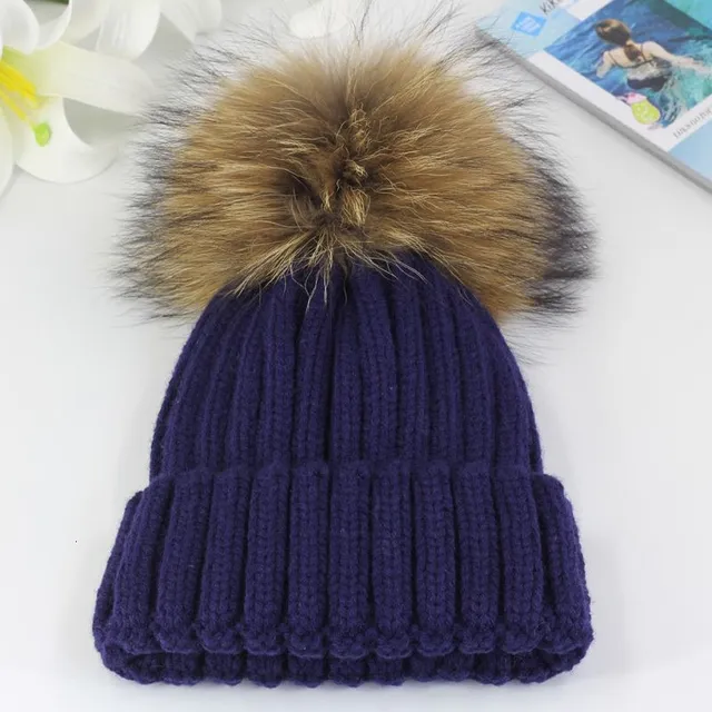 Women's winter knitted hat with pompom made of faux fur