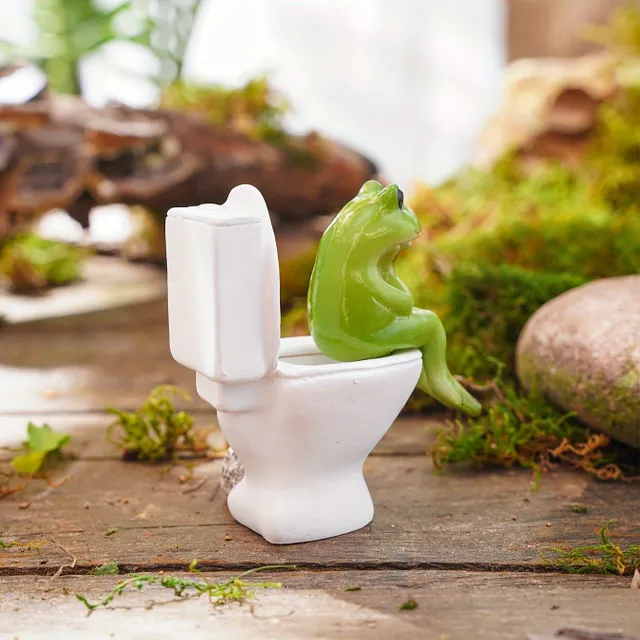 A whimsical frog statue in a resin toilet