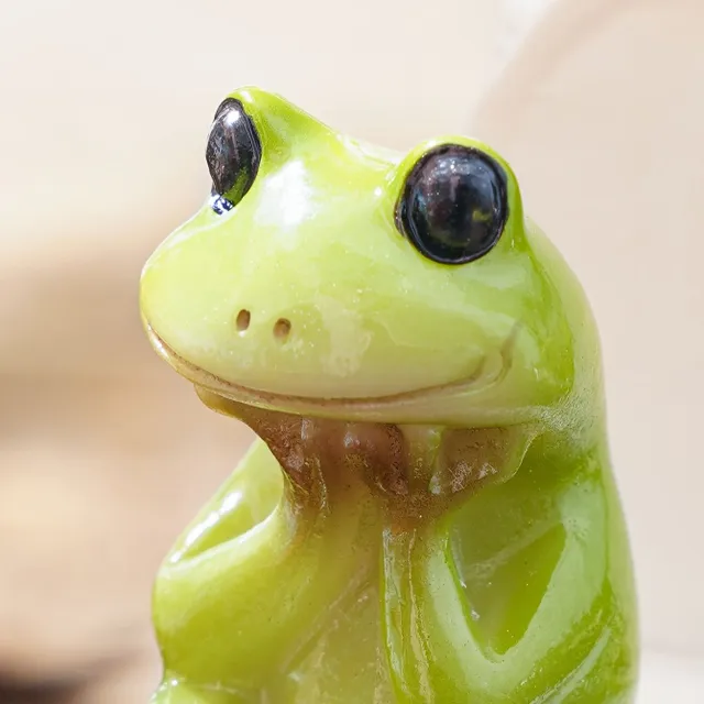 A whimsical frog statue in a resin toilet