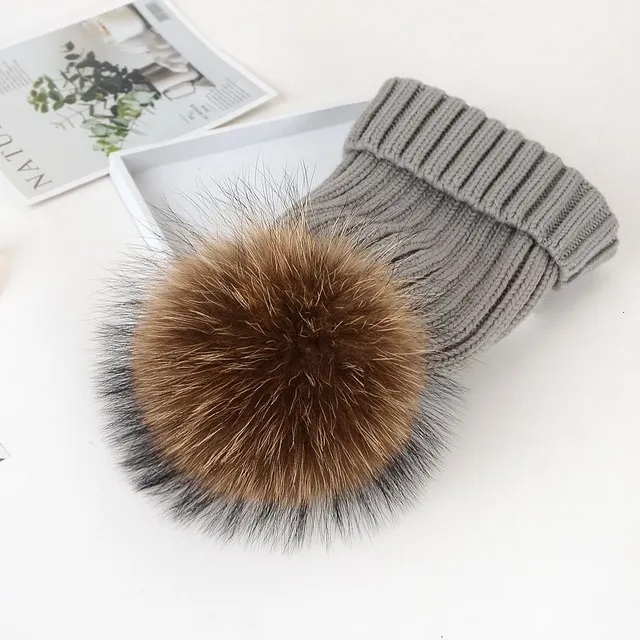 Women's winter knitted hat with pompom made of faux fur