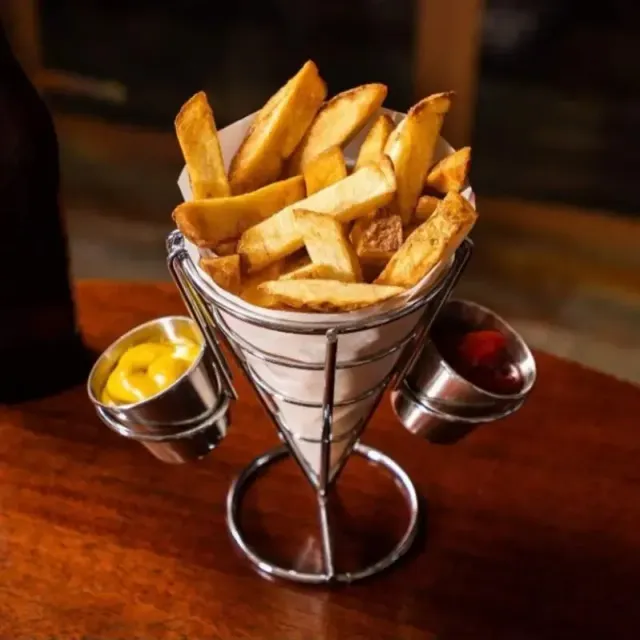 Metal serving basket for fries with 2 sauce bowls and a chicken wing basket