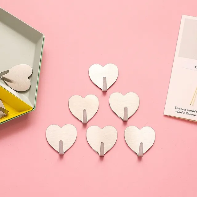 Set of self-adhesive hooks in the shape of a heart on the wall