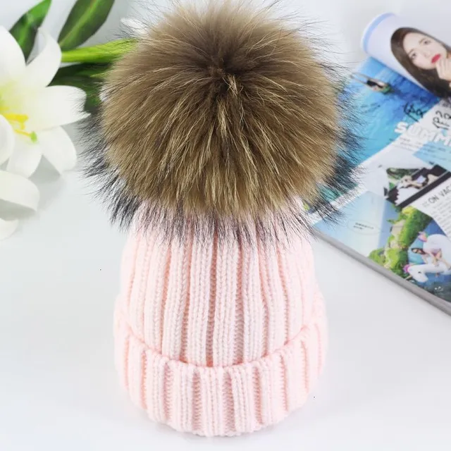 Women's winter knitted hat with pompom made of faux fur