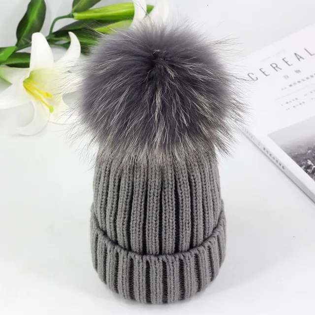 Women's winter knitted hat with pompom made of faux fur