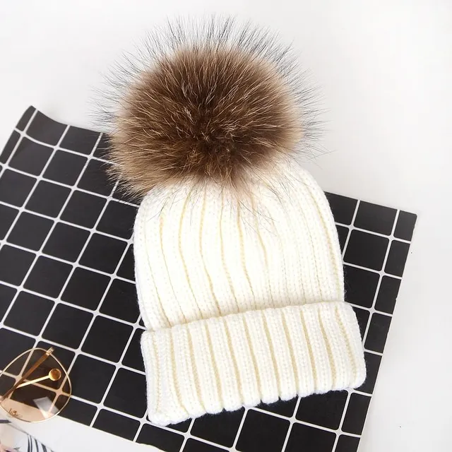 Women's winter knitted hat with pompom made of faux fur