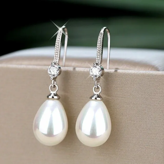 Luxury lady hanger earrings with glittering stones and pearls in elongated shape