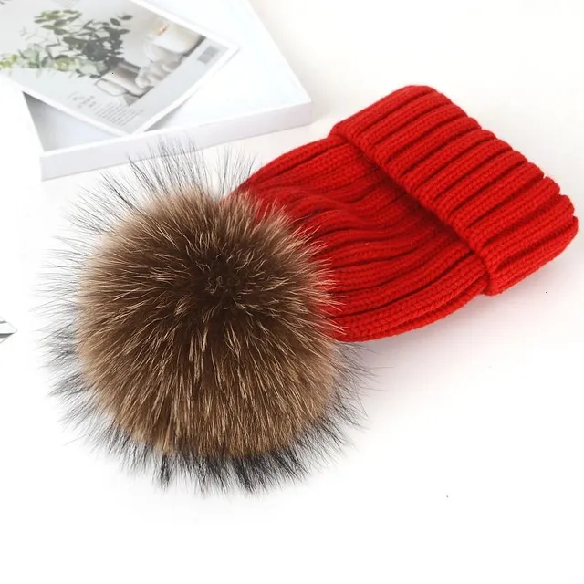 Women's winter knitted hat with pompom made of faux fur