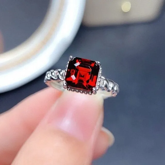 Moderní dámský prstýnek ve stříbrné barvě v zajímavém vzhledu s rudým broušeným kamínkem