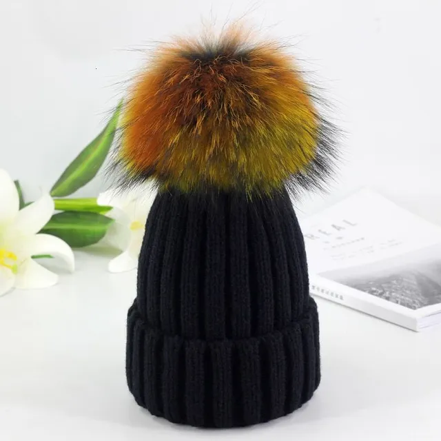 Women's winter knitted hat with pompom made of faux fur