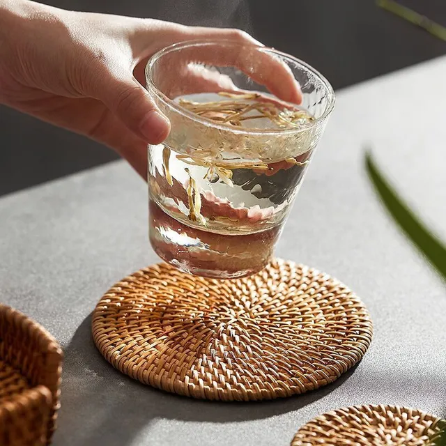 Modern knitted trendy favorite rattan coaster on the table under the cup
