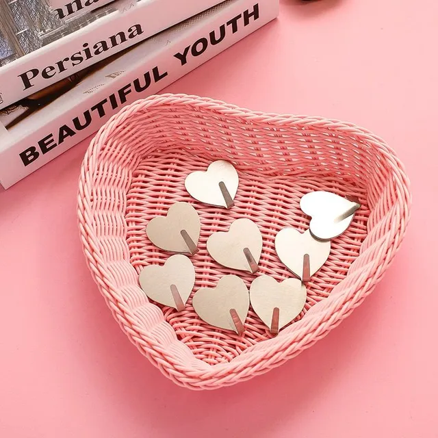 Set of self-adhesive hooks in the shape of a heart on the wall