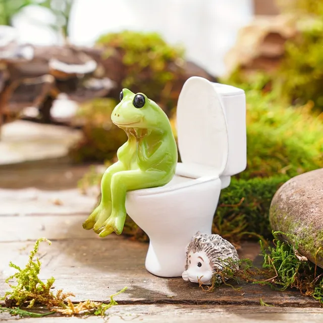 A whimsical frog statue in a resin toilet