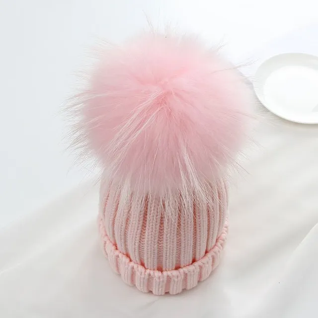 Women's winter knitted hat with pompom made of faux fur