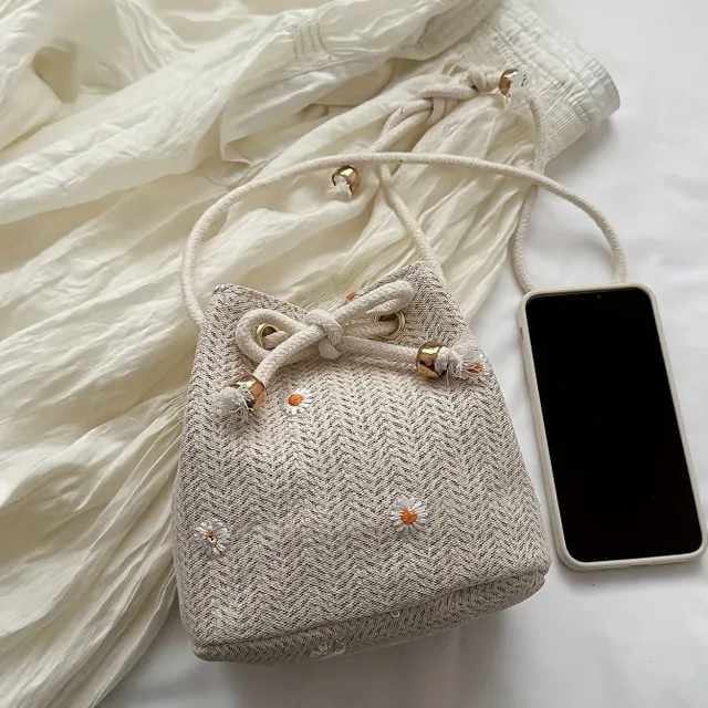 Shoulder bag with minimalist straw design with daisy embroidery