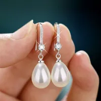 Luxury lady hanger earrings with glittering stones and pearls in elongated shape