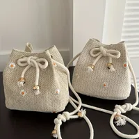 Shoulder bag with minimalist straw design with daisy embroidery