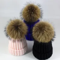 Women's winter knitted hat with pompom made of faux fur