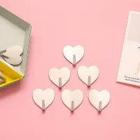 Set of self-adhesive hooks in the shape of a heart on the wall