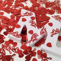 Shiny confetti in the shape of hearts and inscription love